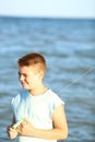 Handsome boy in shorts and a t-shirt teenager launches a kite on the sky on the seashore