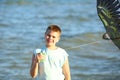 Handsome boy in shorts and a t-shirt teenager launches a kite on the sky on the seashore Royalty Free Stock Photo