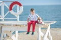 Handsome boy teen happyly spending time together with his friend bulldog on sea side Kid dog holding playing two sea stars close t Royalty Free Stock Photo