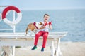 Handsome boy teen happyly spending time together with his friend bulldog on sea side Kid dog holding playing two sea stars close t Royalty Free Stock Photo