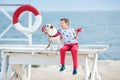 Handsome boy teen happyly spending time together with his friend bulldog on sea side Kid dog holding playing two sea stars close t Royalty Free Stock Photo