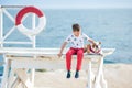 Handsome boy teen happyly spending time together with his friend bulldog on sea side Kid dog holding playing two sea stars close t Royalty Free Stock Photo