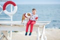 Handsome boy teen happyly spending time together with his friend bulldog on sea side Kid dog holding playing two sea stars close t Royalty Free Stock Photo