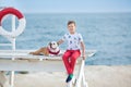 Handsome boy teen happyly spending time together with his friend bulldog on sea side Kid dog holding playing two sea stars close t Royalty Free Stock Photo