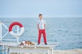 Handsome boy teen happyly spending time together with his friend bulldog on sea side Kid dog holding playing two sea stars close t Royalty Free Stock Photo