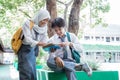 a handsome boy and veiled girl in Indonesian high school uniform reading book together with copy space