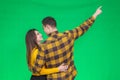 Handsome boyfriend shows his girl a beautiful scene, pointing at it, while they are standing back to the camera.