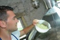 Handsome brewer in uniform during brewing process