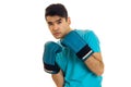 Handsome brunette sportsman in blue boxing gloves and uniform practicing boxing isolated on white background Royalty Free Stock Photo