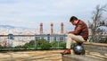 Handsome brutal stylish adult sad gentleman sitting on bench  against background of fantastic panorama of Barcelona on  Montjuic Royalty Free Stock Photo