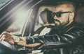 Handsome brutal young man behind the wheel of a luxury car