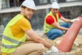 Skilled workers placing a corrugated drainage pipe into a concrete manhole Royalty Free Stock Photo