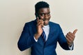 Handsome business black man having conversation talking on the smartphone pointing thumb up to the side smiling happy with open Royalty Free Stock Photo