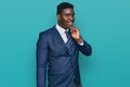 Handsome business black man wearing business suit and tie looking confident at the camera with smile with crossed arms and hand Royalty Free Stock Photo