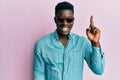 Handsome business black man wearing stylish sunglasses pointing finger up with successful idea Royalty Free Stock Photo