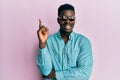 Handsome business black man wearing stylish sunglasses smiling happy pointing with hand and finger to the side Royalty Free Stock Photo