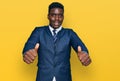 Handsome business black man wearing business suit and tie approving doing positive gesture with hand, thumbs up smiling and happy Royalty Free Stock Photo