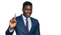 Handsome business black man wearing business suit and tie showing and pointing up with finger number one while smiling confident Royalty Free Stock Photo