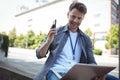 Handsome business executive holding mobile phone and laptop Royalty Free Stock Photo