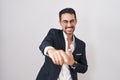 Handsome business hispanic man standing over white background laughing at you, pointing finger to the camera with hand over body, Royalty Free Stock Photo