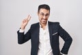 Handsome business hispanic man standing over white background smiling looking to the camera showing fingers doing victory sign Royalty Free Stock Photo