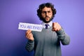 Handsome business man with beard holding you are fired message over purple background pointing with finger to the camera and to Royalty Free Stock Photo