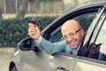 Handsome business man male looking back out of window holding car keys in hand showing his new car Royalty Free Stock Photo