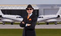 Handsome business man standing in front of private jets Royalty Free Stock Photo