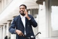 Handsome business man talking on phone holding bike Royalty Free Stock Photo