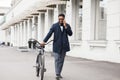 Handsome business man talking on phone holding his bike Royalty Free Stock Photo