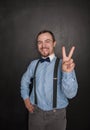 Handsome business man with victory gesture on blackboard Royalty Free Stock Photo