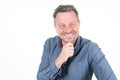 Handsome business man wearing elegant blue shirt looking confident at camera smiling with hand raised on chin in white background Royalty Free Stock Photo