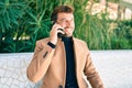 Handsome business man wearing elegant jacket using smartphone smiling happy outdoors Royalty Free Stock Photo