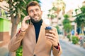 Handsome business man wearing elegant jacket using smartphone smiling happy outdoors Royalty Free Stock Photo