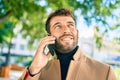 Handsome business man wearing elegant jacket using smartphone smiling happy outdoors Royalty Free Stock Photo