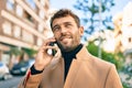 Handsome business man wearing elegant jacket using smartphone smiling happy outdoors Royalty Free Stock Photo