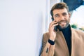 Handsome business man wearing elegant jacket using smartphone smiling happy outdoors Royalty Free Stock Photo