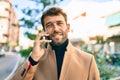 Handsome business man wearing elegant jacket using smartphone smiling happy outdoors Royalty Free Stock Photo