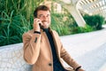 Handsome business man wearing elegant jacket using smartphone smiling happy outdoors Royalty Free Stock Photo