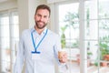 Handsome business man wearing id bagde with a big smile on face while drinking take away coffee in a paper cup Royalty Free Stock Photo
