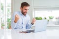 Handsome business man working using computer laptop screaming proud and celebrating victory and success very excited, cheering Royalty Free Stock Photo