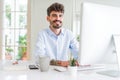 Handsome business young man working using computer, smiling confident and concentrated at the office Royalty Free Stock Photo