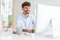 Handsome business young man working using computer, smiling confident and concentrated at the office Royalty Free Stock Photo