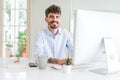 Handsome business young man working using computer, smiling confident and concentrated at the office Royalty Free Stock Photo