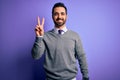 Handsome businessman with beard wearing casual tie standing over purple background showing and pointing up with fingers number two Royalty Free Stock Photo