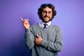 Handsome businessman with beard wearing tie and glasses standing over purple background with a big smile on face, pointing with Royalty Free Stock Photo