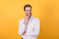 Handsome businessman with bristle wearing white shirt standing on orange background, business fashion