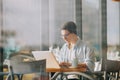 Handsome businessman in casual wear and eyeglasses is using a laptop in cafe Royalty Free Stock Photo