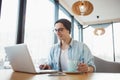 Handsome businessman in casual wear and eyeglasses is using a laptop in cafe Royalty Free Stock Photo