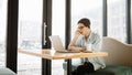 Handsome businessman in casual wear and eyeglasses is using a laptop in cafe Royalty Free Stock Photo